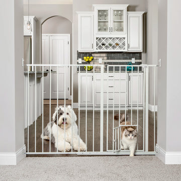 Carlson Maxi Extra Tall Walk-Thru Pet Gate in white with small pet door. Designed for wide openings (51"-59"), it stands 38" tall to contain larger or active pets. Features a 15.9" wide walk-through door, easy lever-style handle, and secure hardware mount for durable, long-lasting use.
