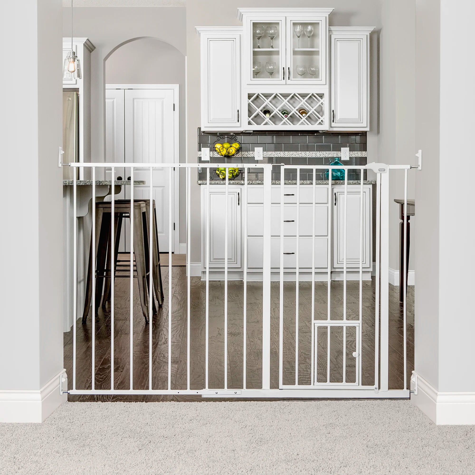 Carlson Maxi Extra Tall Walk-Thru Pet Gate in white with small pet door. Designed for wide openings (51"-59"), it stands 38" tall to contain larger or active pets. Features a 15.9" wide walk-through door, easy lever-style handle, and secure hardware mount for durable, long-lasting use.