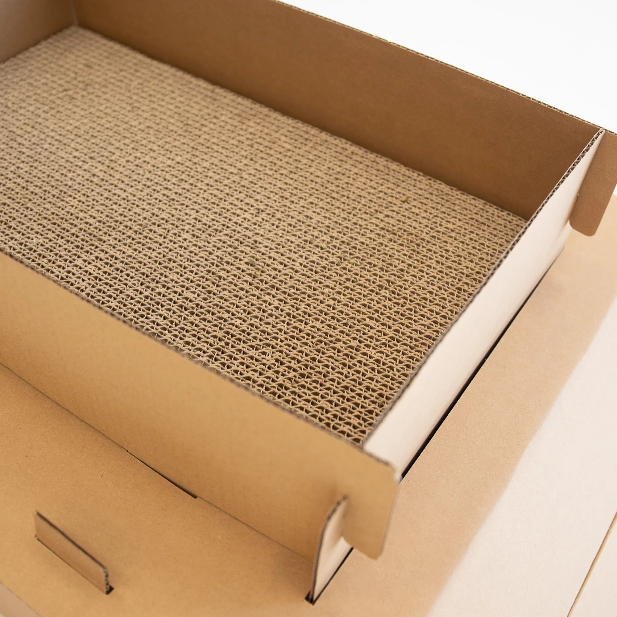 The Carlson Cat Camper and Scratcher is a compact, eco-friendly playhouse made from durable cardboard. Featuring a cat door, three paw-shaped windows, and a removable scratcher, it provides a cozy, entertaining space for small animals like cats and rabbits. Easy to assemble and lightweight for easy transport.