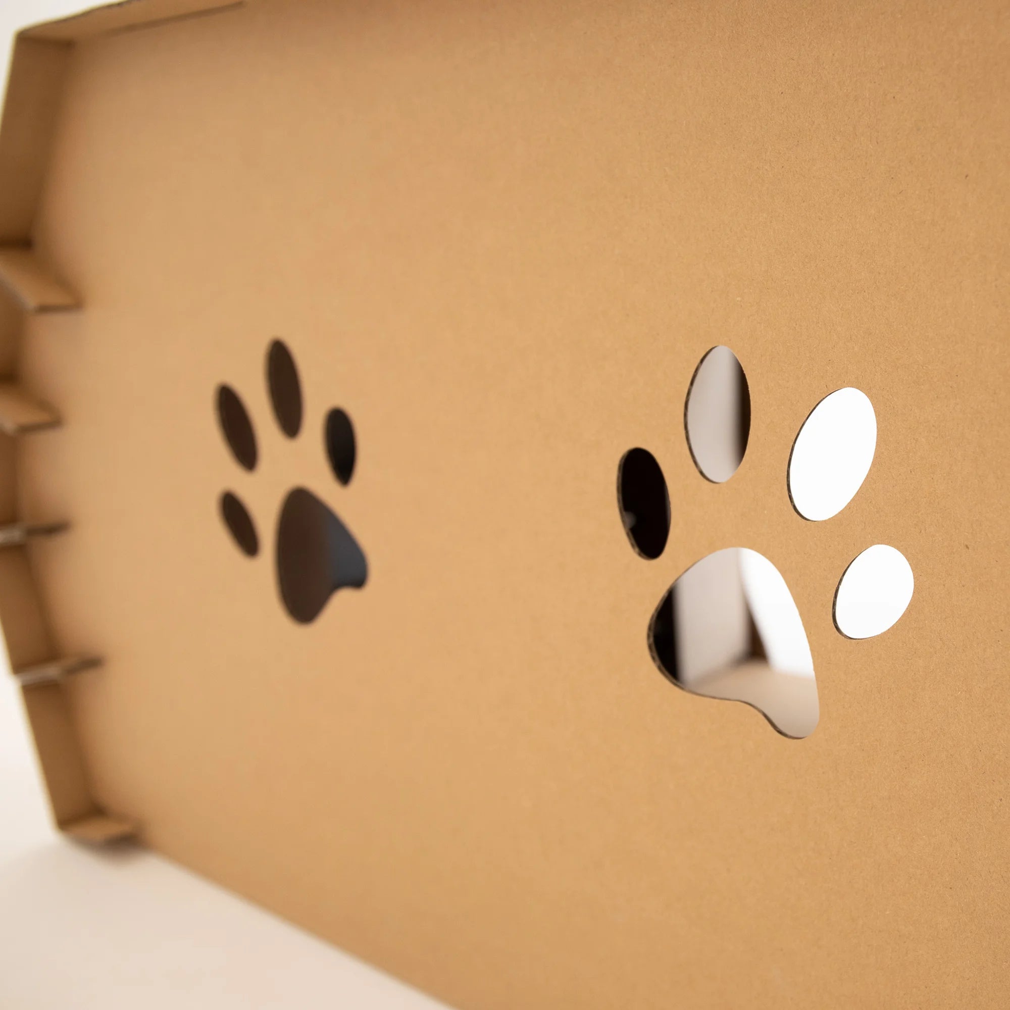 The Carlson Cat Camper and Scratcher is a compact, eco-friendly playhouse made from durable cardboard. Featuring a cat door, three paw-shaped windows, and a removable scratcher, it provides a cozy, entertaining space for small animals like cats and rabbits. Easy to assemble and lightweight for easy transport.