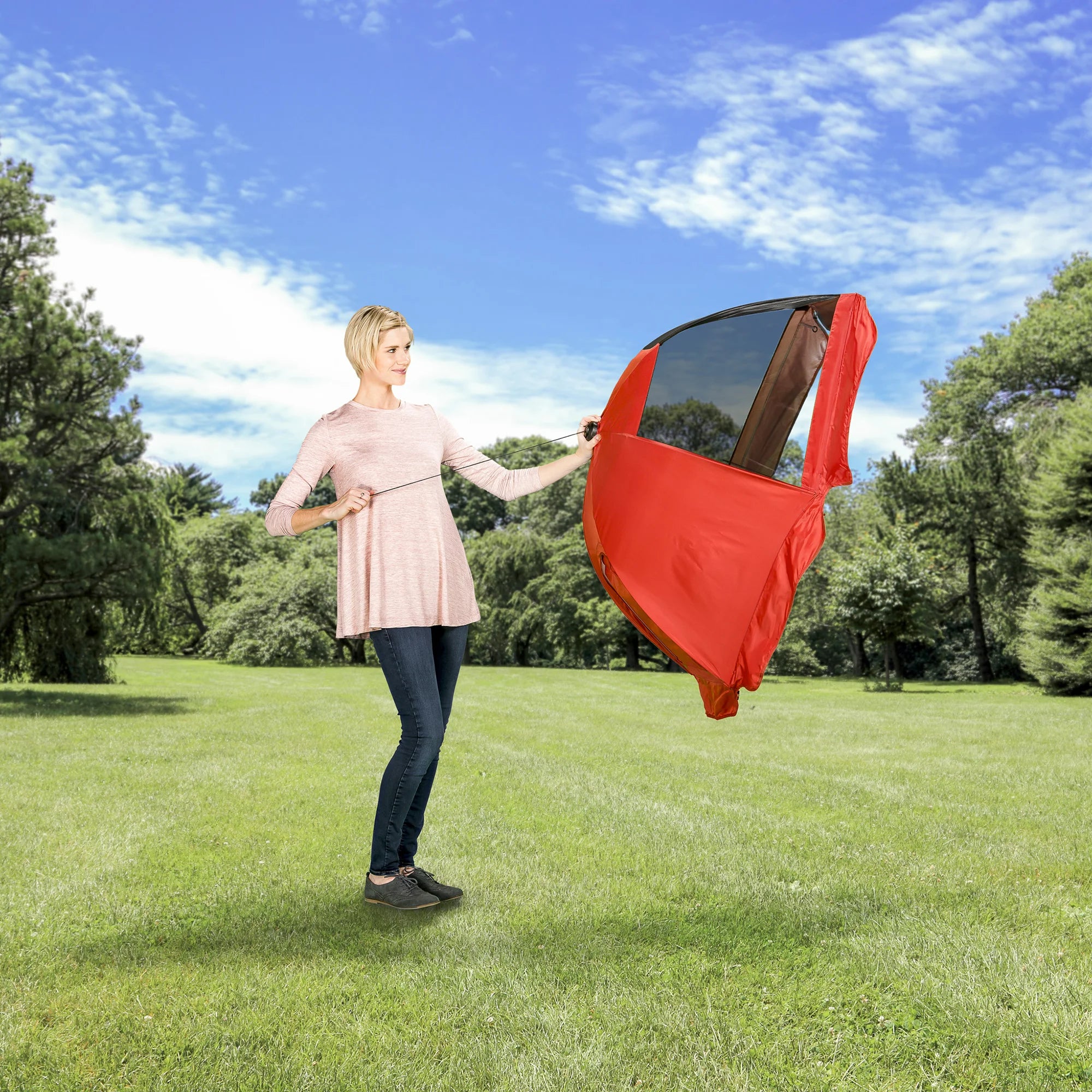 Woman opening the canopy of the Portable Pet Pen while in a park.