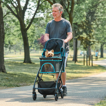 Carlson Easy Fold & Go Pet Stroller in black with blue trim, featuring large mesh panels, zippered canopy, and easy one-handed fold for convenient storage.