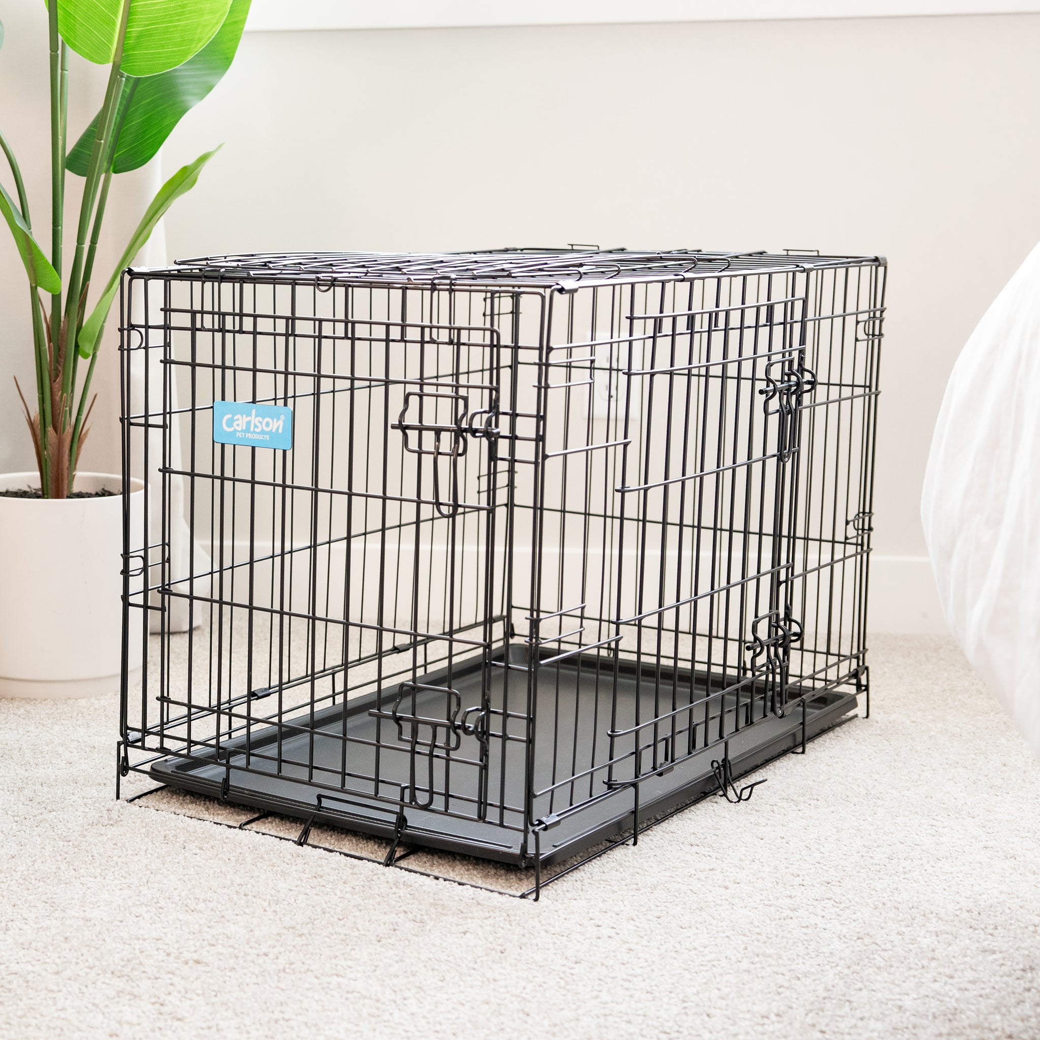 The Carlson Medium Double-Door Dog Crate features a sturdy steel wire construction, offering a safe and comfortable space for small to medium-sized dogs up to 24” long. It includes two access doors, a removable pan for easy cleaning, and folds flat for convenient storage and transport. Ideal for training and containment.