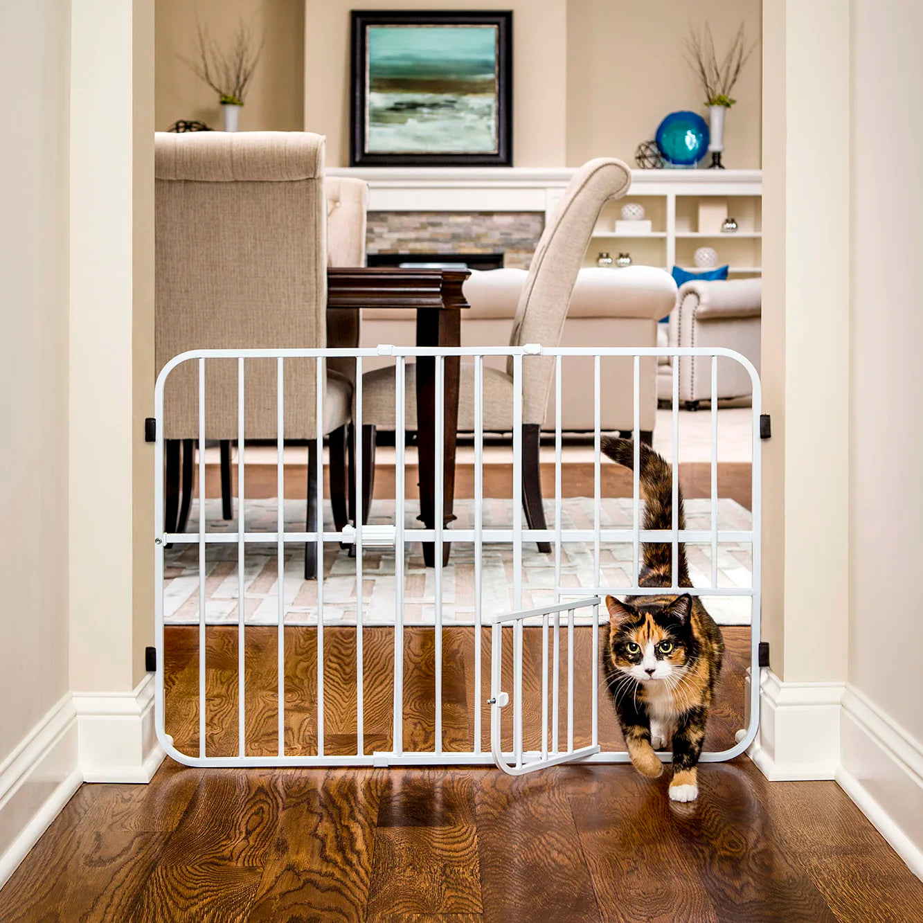 Cat walking through small pet door of Tuffy® Pet Gate in the dining room and kitchen.