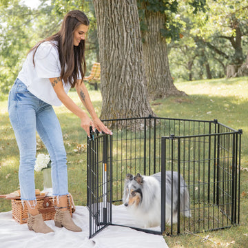 Woman at the park opening Outdoor Super Wide Pen Pen and Gate for small dog.