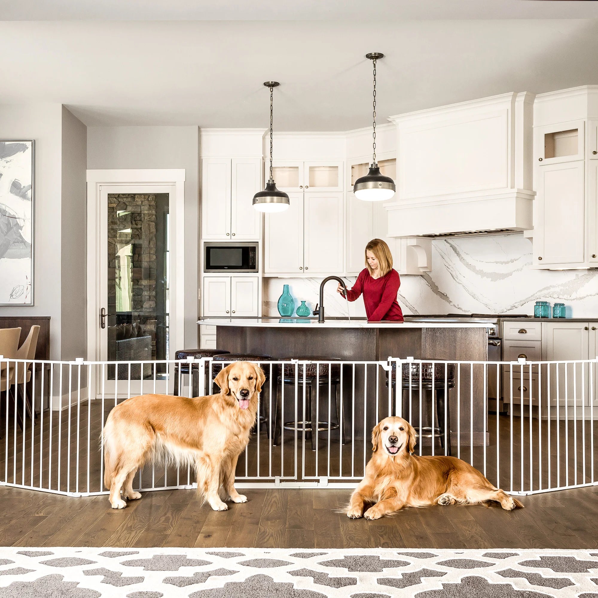 Two dogs sitting on the floor while sitting in front of the Double Door Super Wide Pet Gate and Pet Yard.