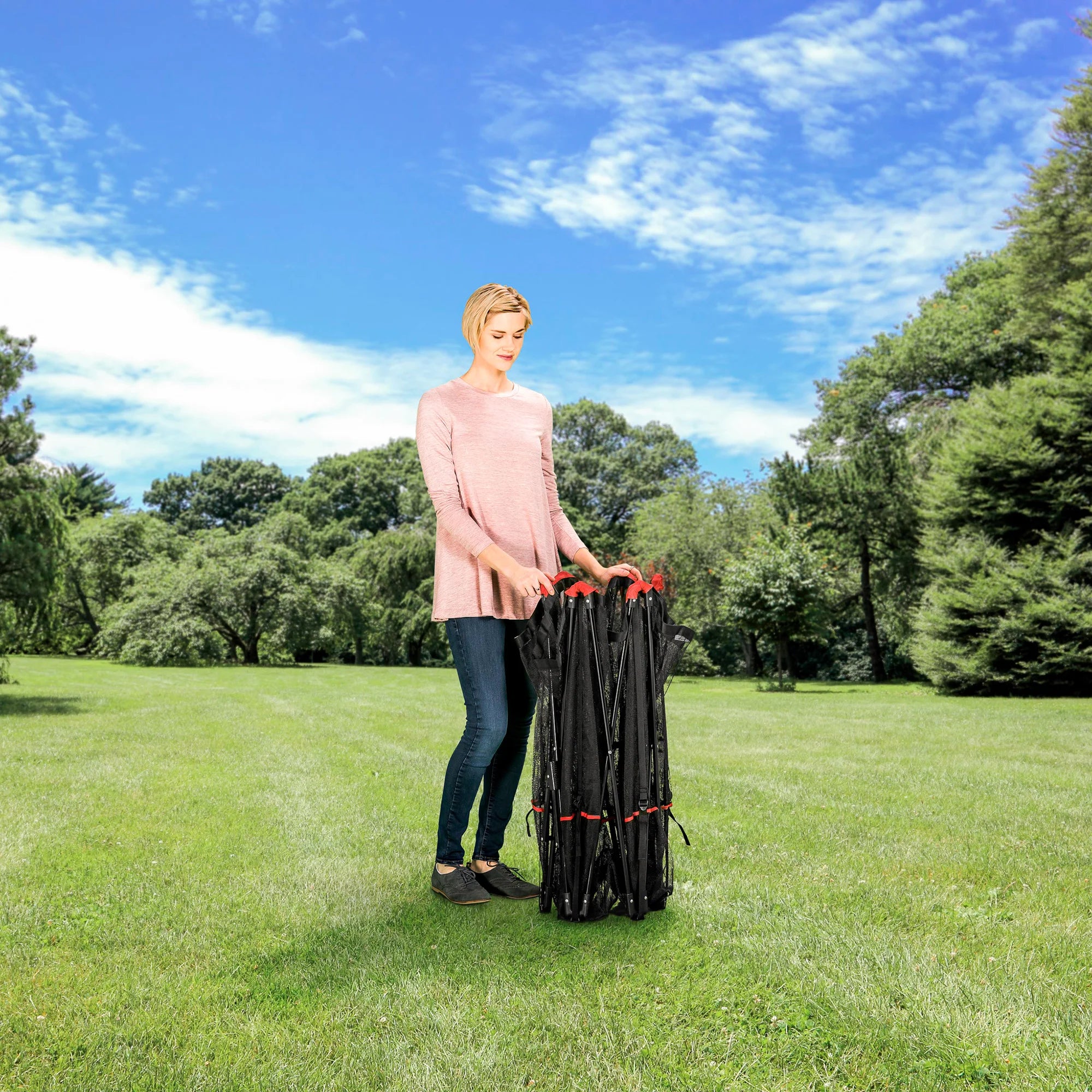 Woman holding the Portable Pet Pen while at a park.