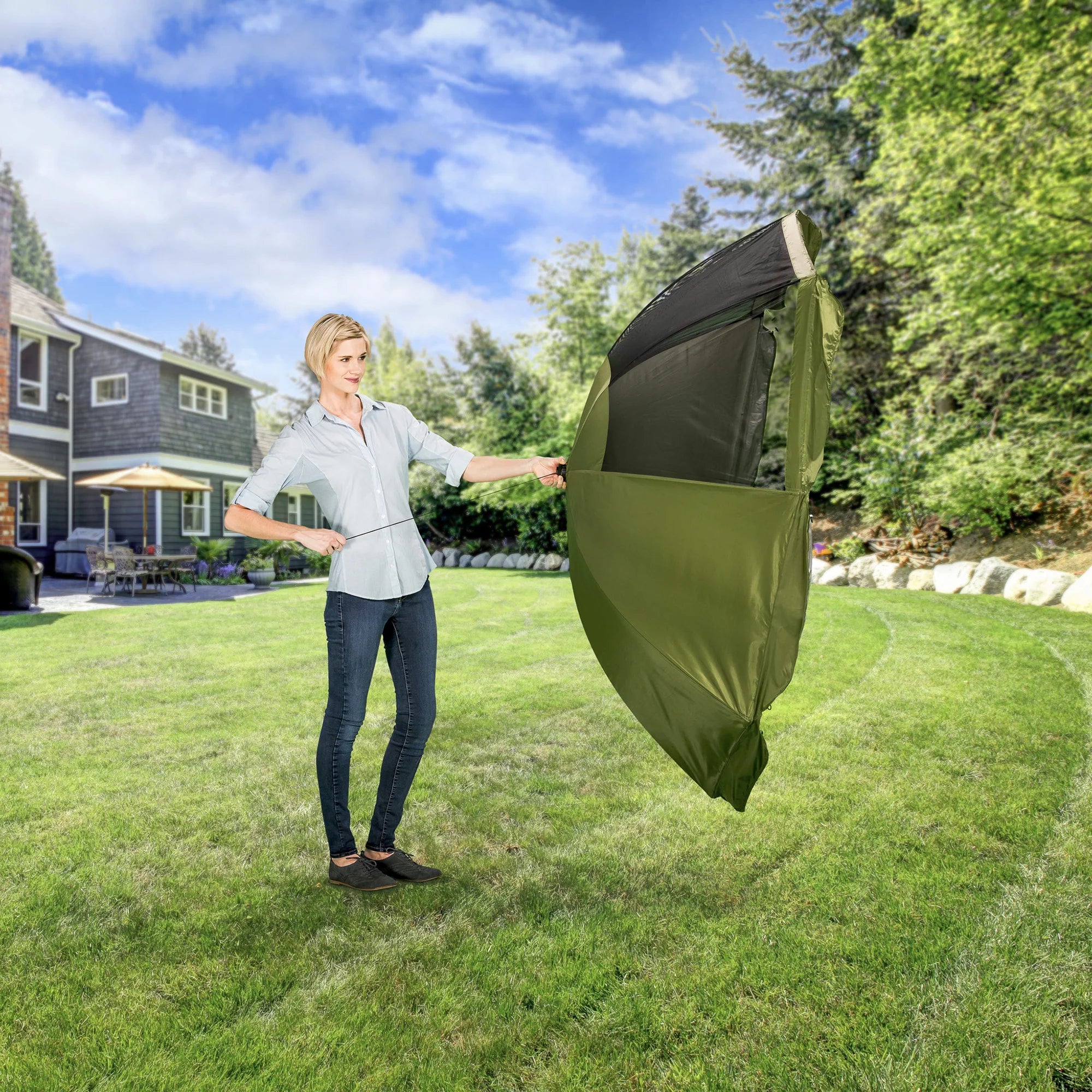 A woman opening the Canopy of the Portable Pet Pen on a green space in a backyard.
