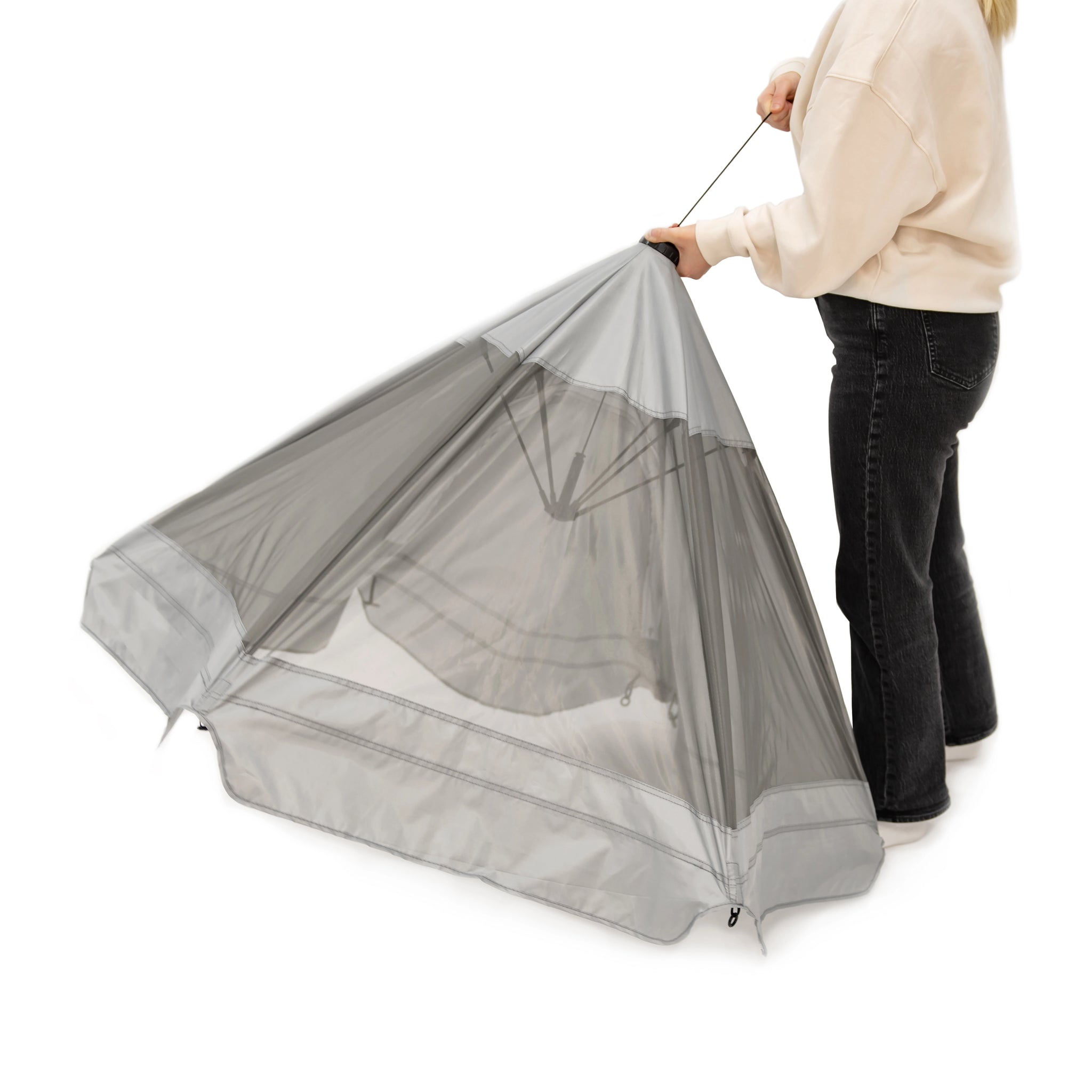 Person holding a gray top to pet pen on a white background